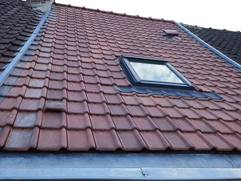 Couverture en tuiles rouges neuves avec fenêtre de toit Velux installée par Colors’Pro