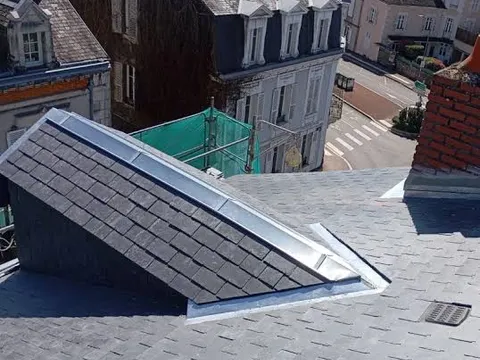 Détail de zinguerie et solin autour d’une fenêtre de toit sur couverture ardoise